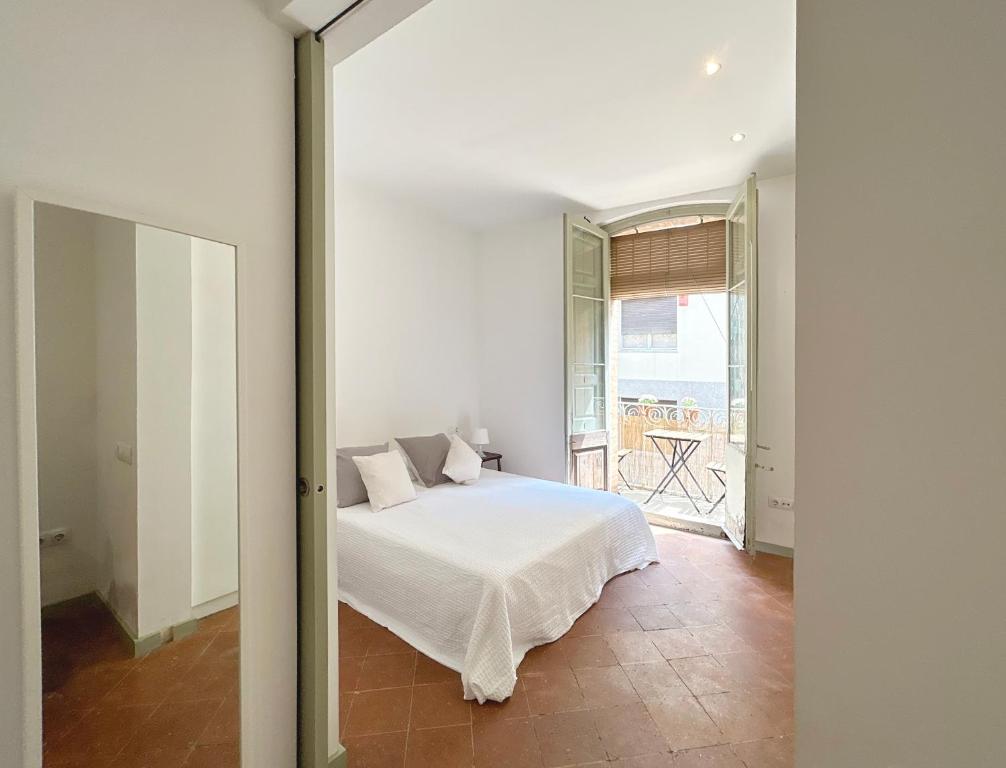 a bedroom with a white bed and a window at SC Apartamento céntrico con balcón in Terrassa