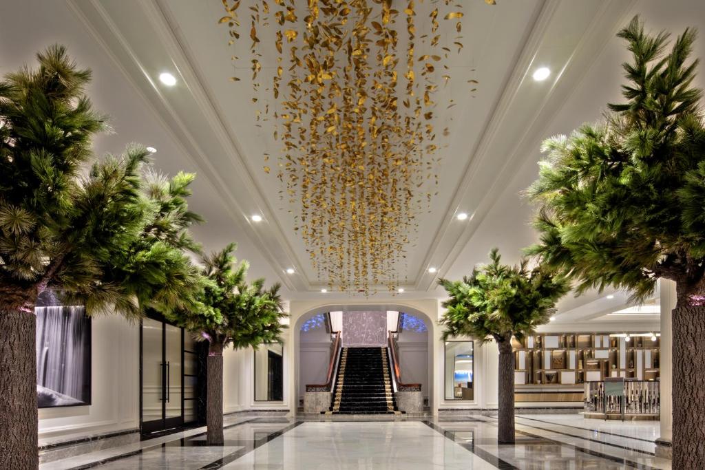 a lobby with palm trees and a gold chandelier at Four Seasons Chicago in Chicago