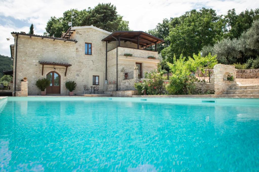 eine Villa mit einem Pool vor einem Haus in der Unterkunft Volver B&B Spoleto in Spoleto