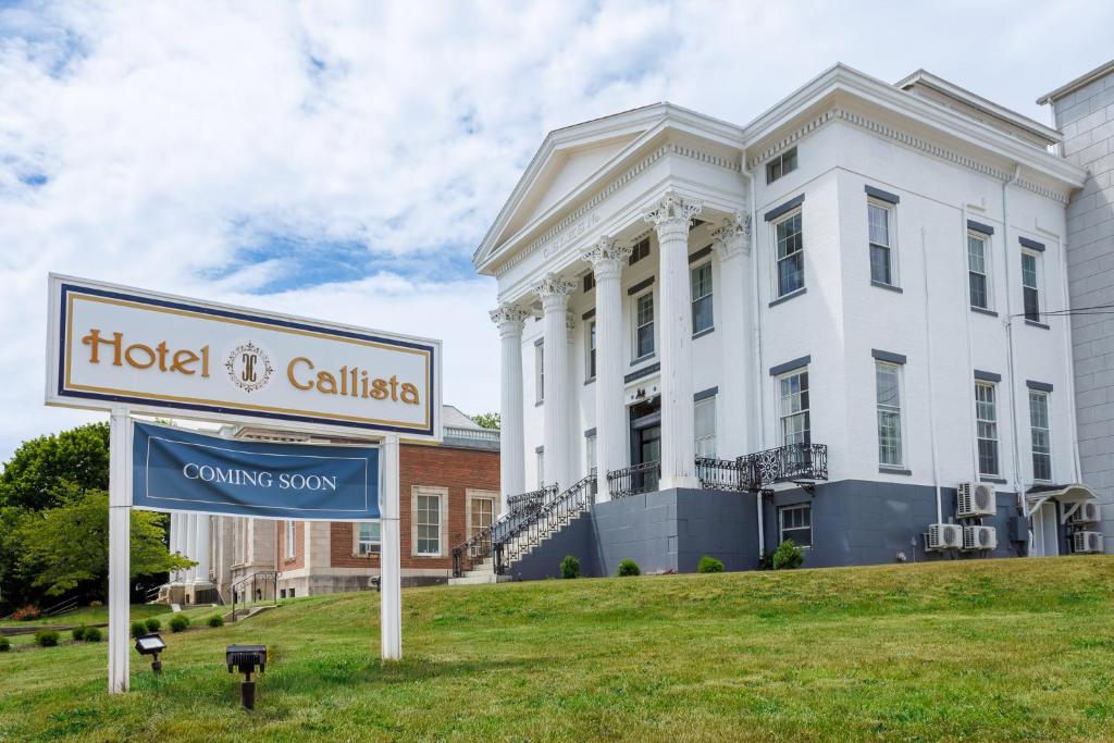 a sign in front of a white building at Hotel Callista in Norwich