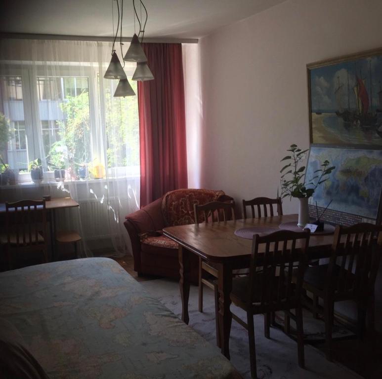 a living room with a table and a couch at Jaukus butas ant Neries skardžio in Vilnius