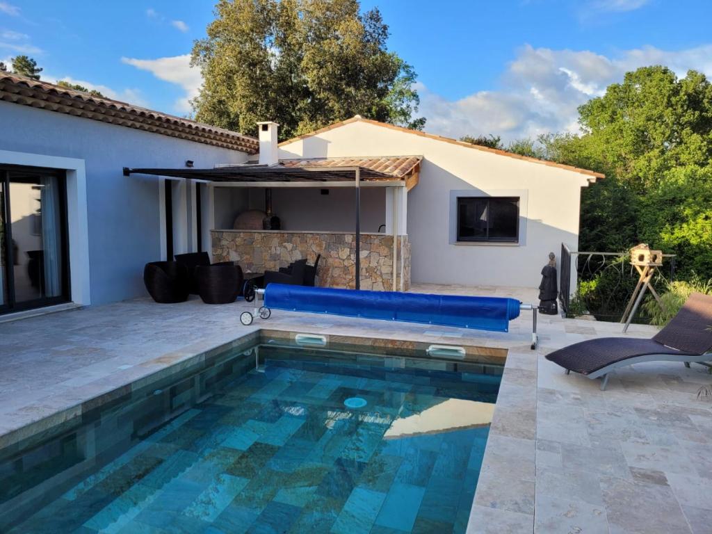 a swimming pool in front of a house at Villa au calme in Montauroux