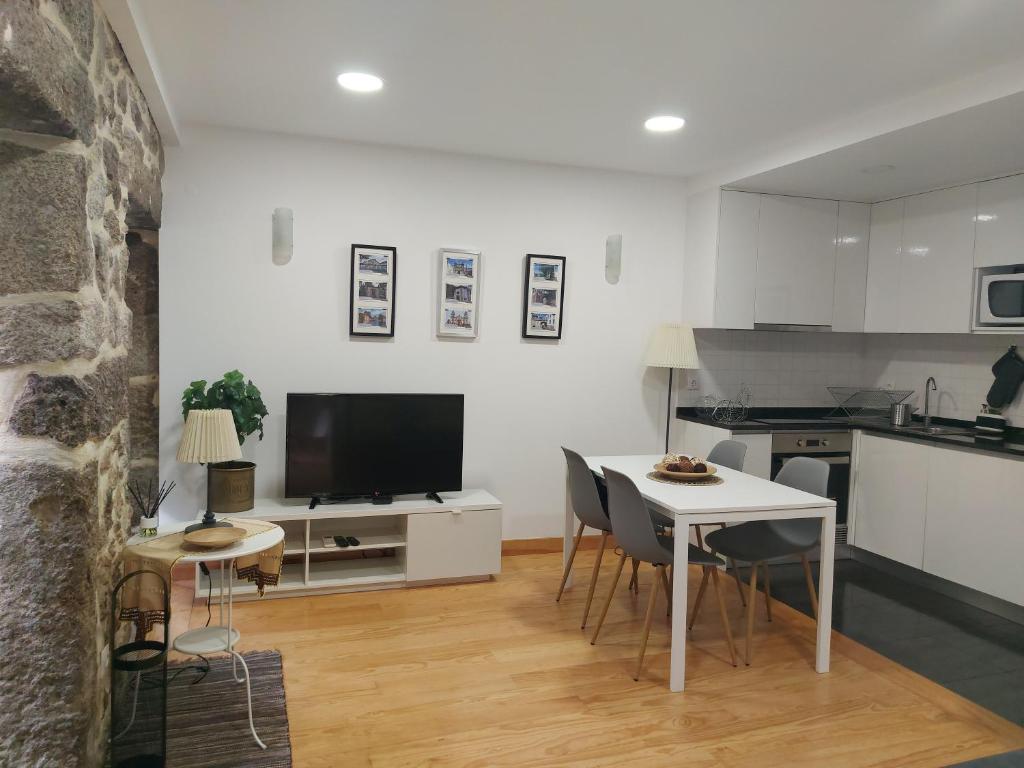 a kitchen and living room with a table and chairs at Enjoy Viseu in Viseu