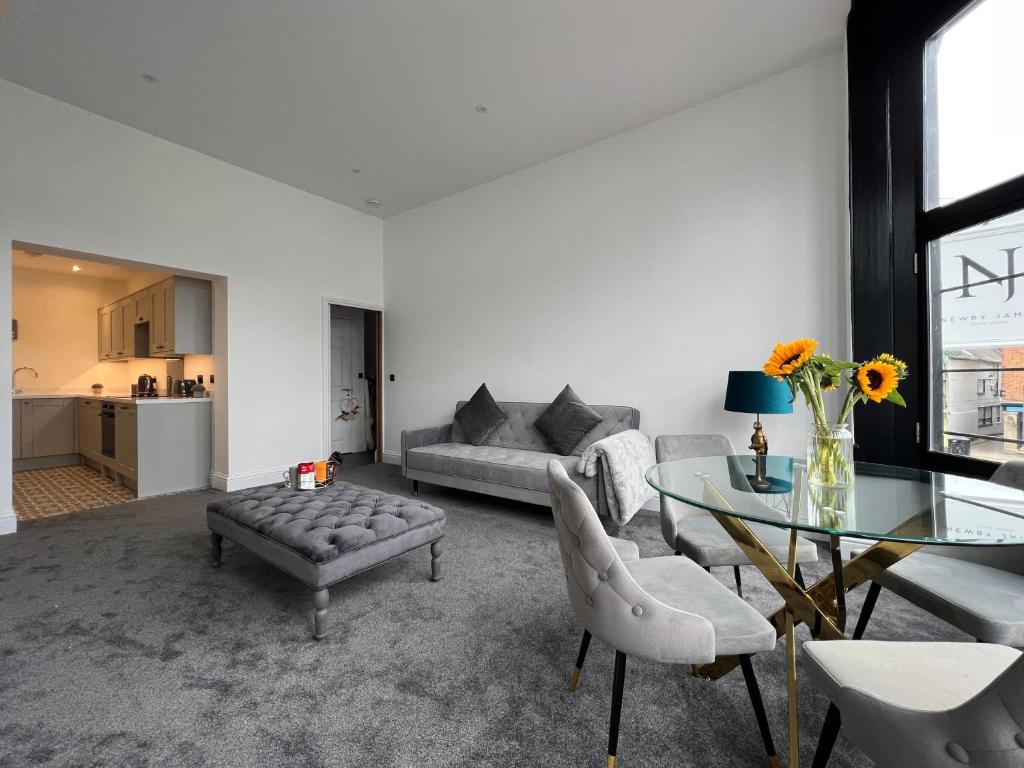 een woonkamer met een bank en een glazen tafel bij Black Horse Apartments in Knaresborough