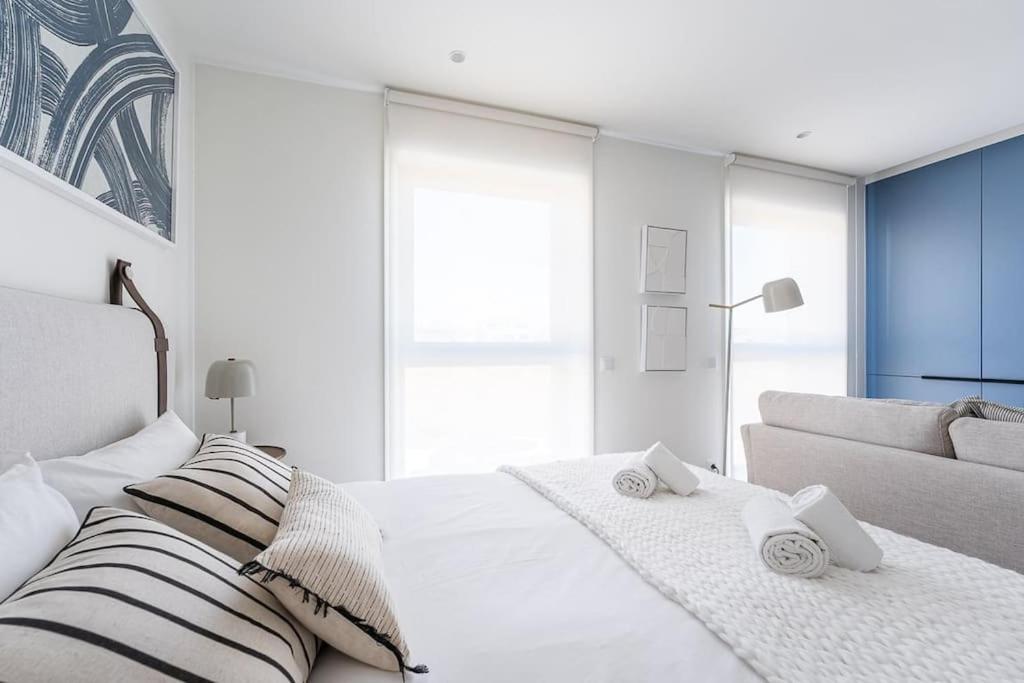 a white bedroom with a bed and a couch at GuestReady - Cosy Nests in Porto in Porto