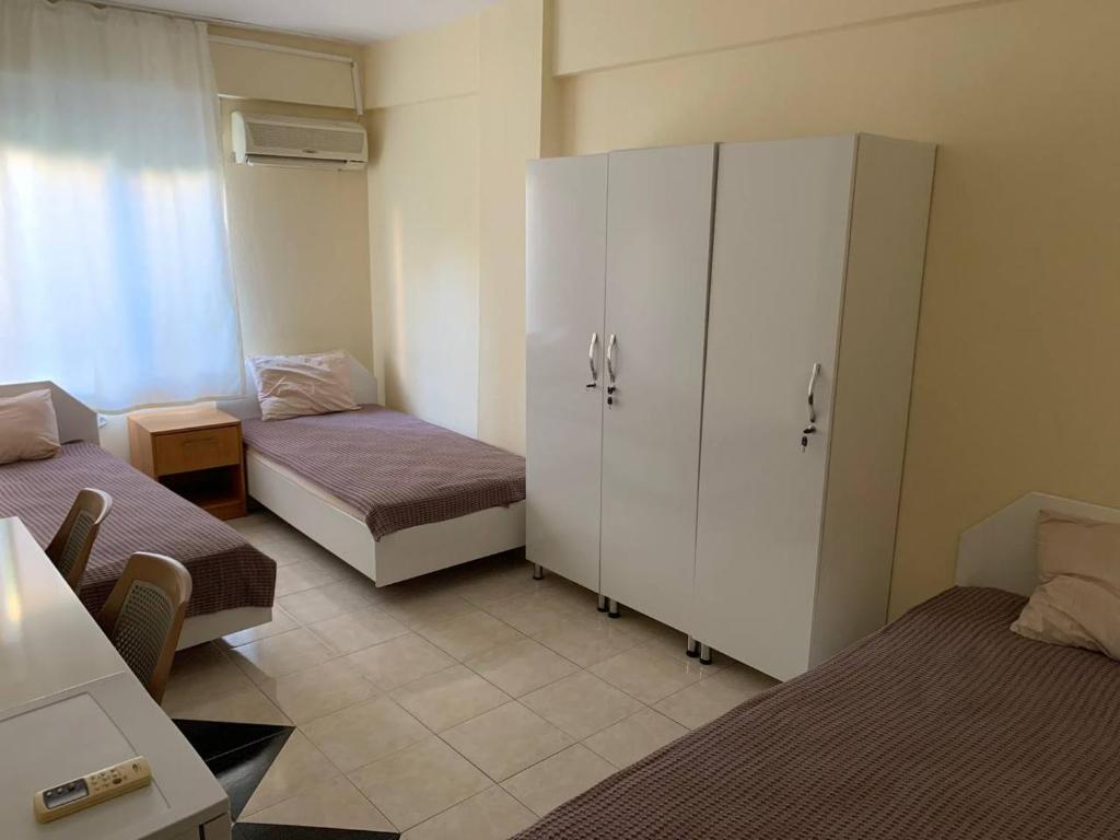 een kleine kamer met 2 bedden en een kast bij Arma pansiyon in Antalya