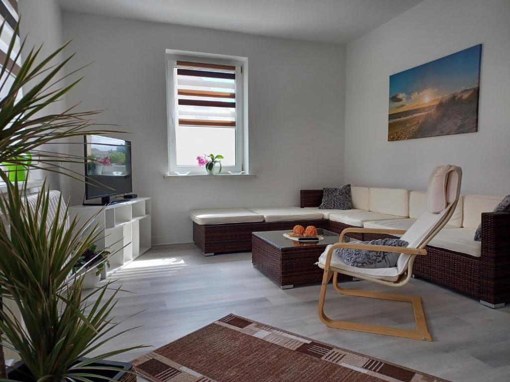 ein Wohnzimmer mit einem Sofa und einem TV in der Unterkunft FeWo s Runde Wiese WR in Greifswald