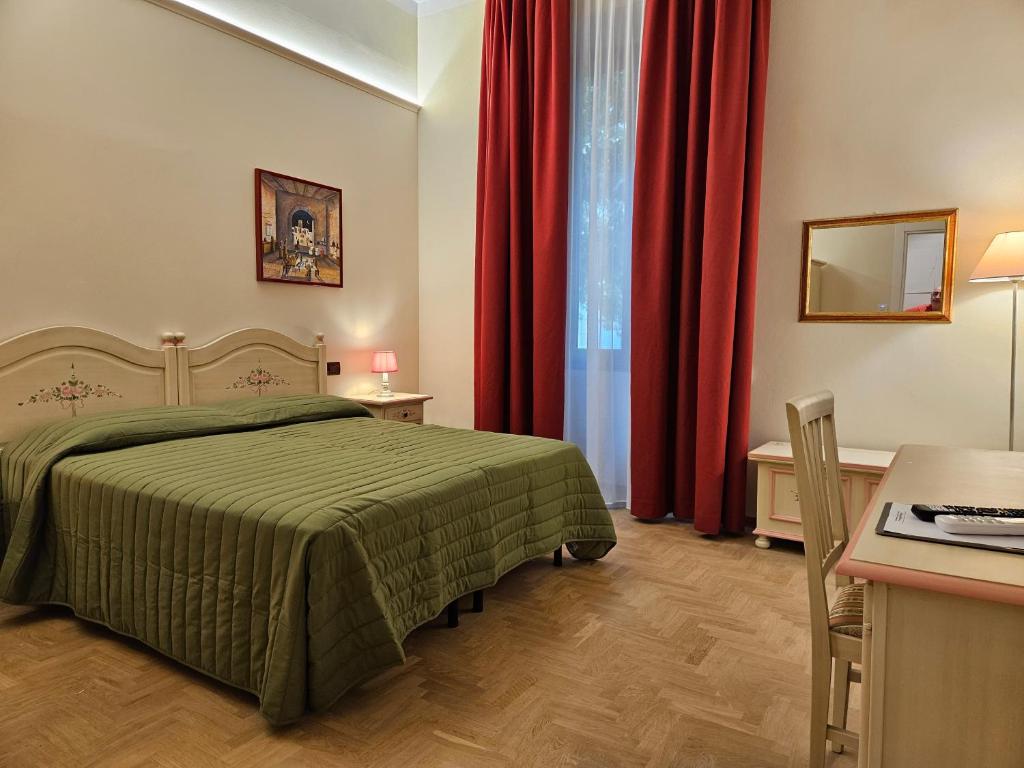 Schlafzimmer mit grünem Bett und roten Vorhängen in der Unterkunft Resort del Roster in Florenz