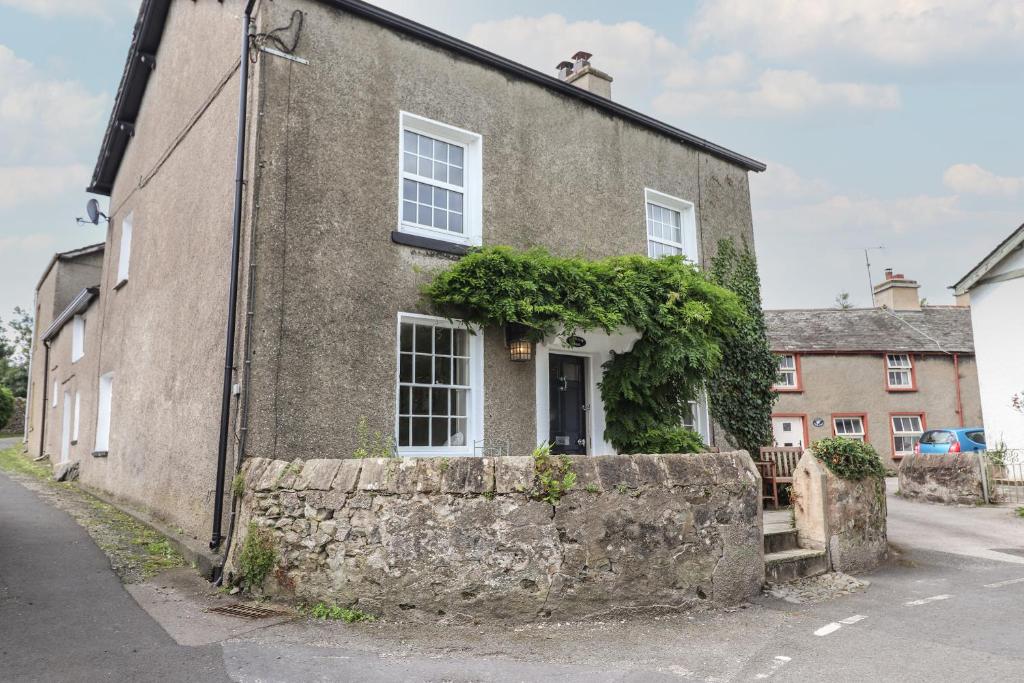 a house with a stone wall in front of it at Caton Lane House in Grange Over Sands
