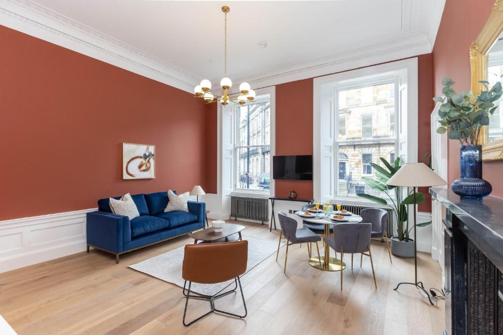 a living room with a blue couch and a table at Dragon Suites Luxury Serviced Apartments at Walker Street in Edinburgh