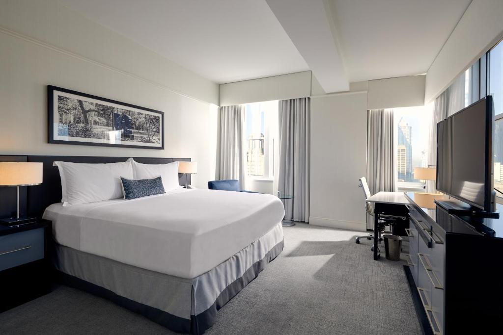 a bedroom with a bed and a desk and a television at Loews Philadelphia Hotel in Philadelphia