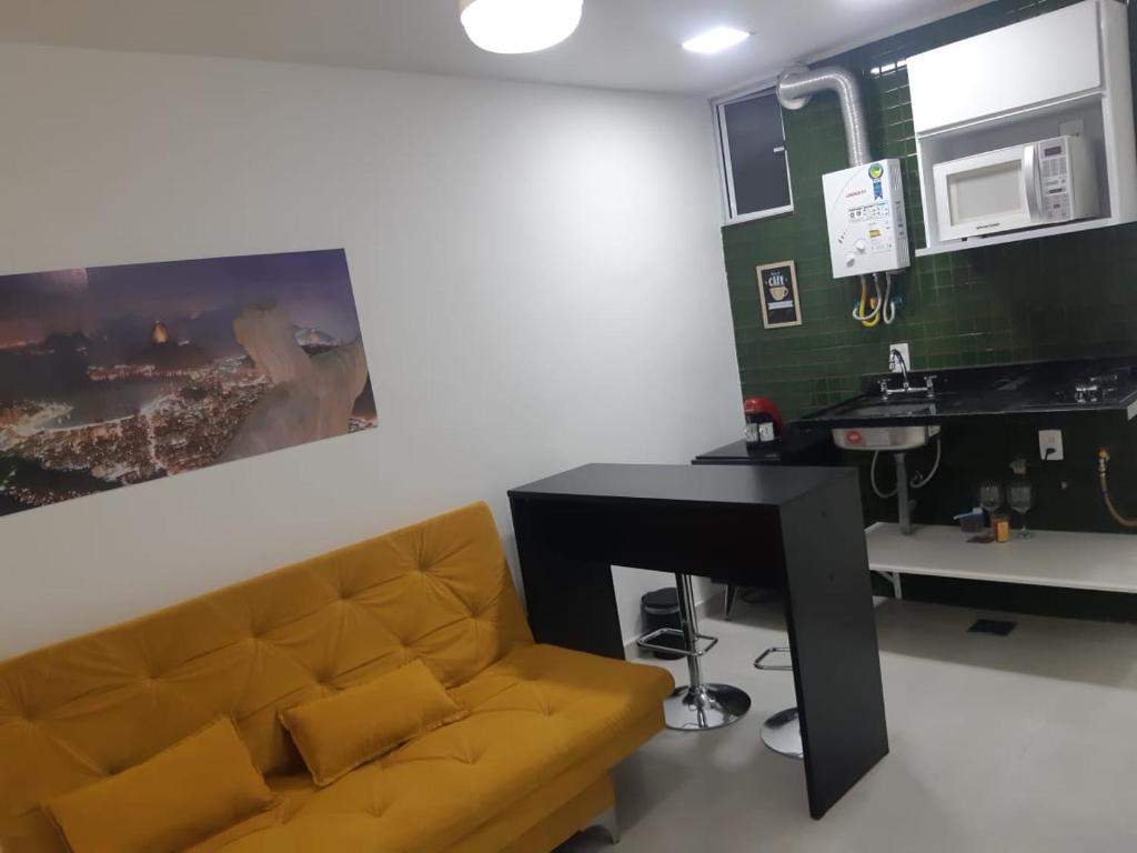 a living room with a couch and a desk at Lev Apartments - Apto Beira-Mar - Posto 2 - Copacabana in Rio de Janeiro