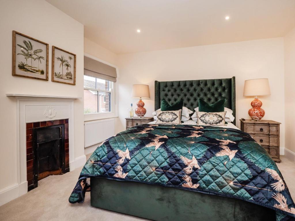 a bedroom with a bed and a fireplace at The Stag Pub, Beech Room in Salhouse