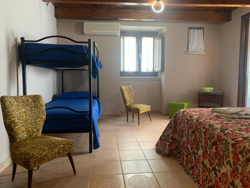 una camera con un letto a castello, un letto e una sedia di CD Romanello (Mura S. Cataldo) a Barletta