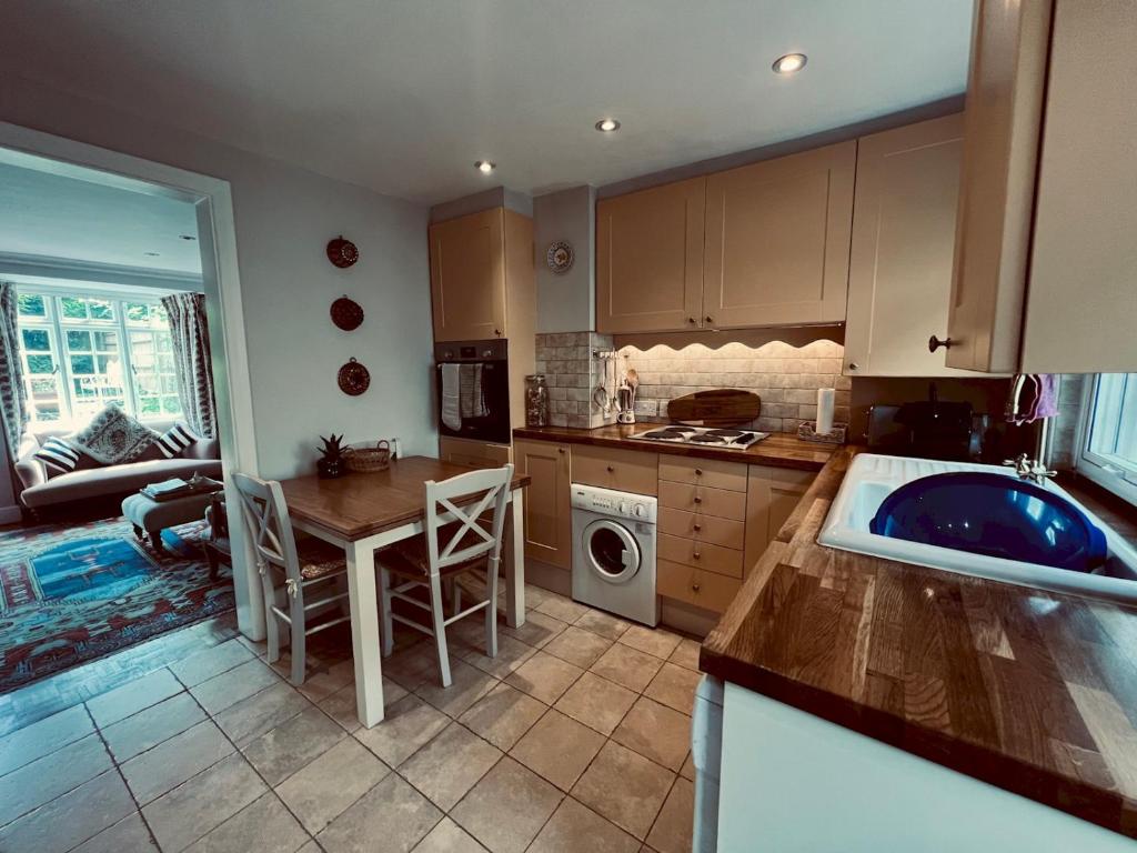 eine Küche mit Spüle, Tisch und Arbeitsplatte in der Unterkunft Pass the Keys Scallop Cottage Oasis of Calm in Rye