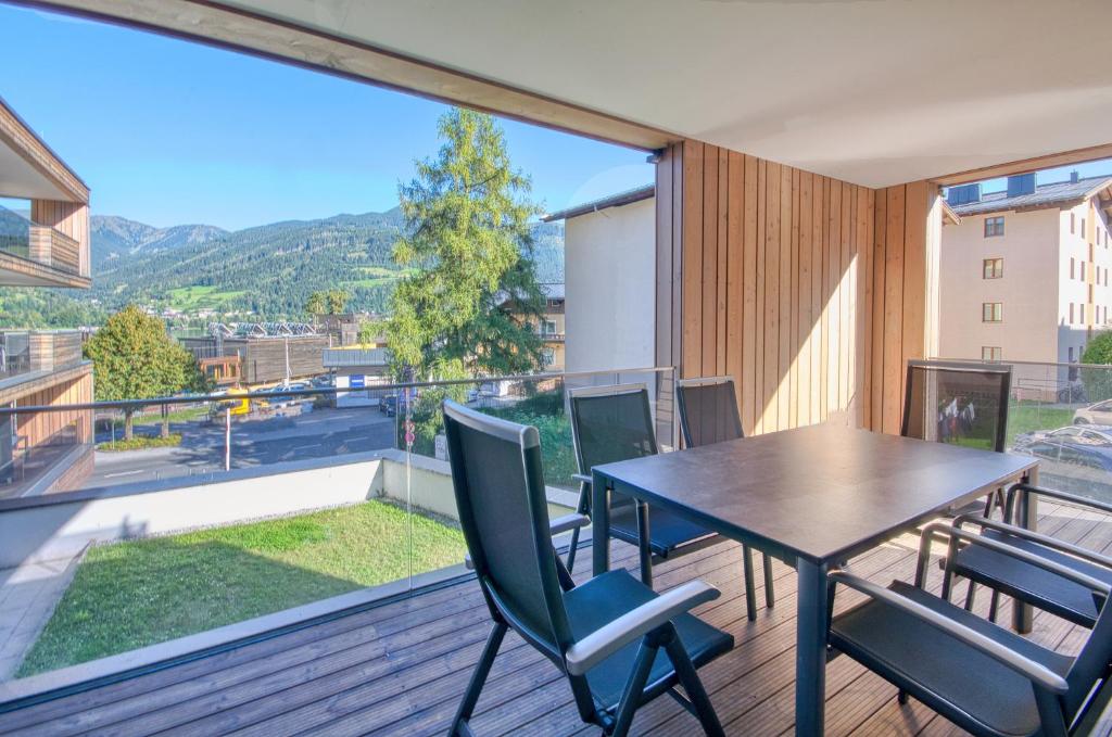 Alpin & Seeresort Top 10 - by Alpen Apartments في زيل أم سي: غرفة طعام مع طاولة وكراسي على شرفة