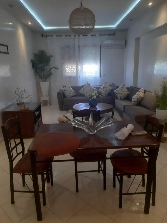 sala de estar con mesa y sofá en APPARTEMENT Hana Majorelle en Marrakech