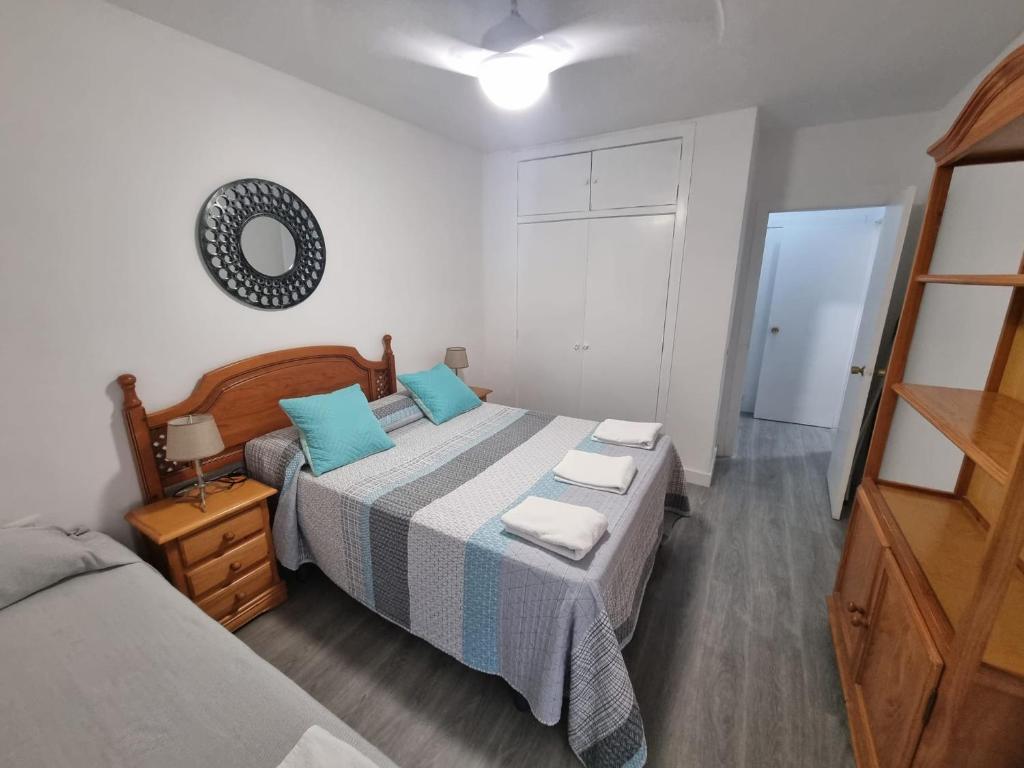 1 dormitorio con 2 camas y espejo en Apartamento Acogedor en Los Patios De San Basilio, en Córdoba