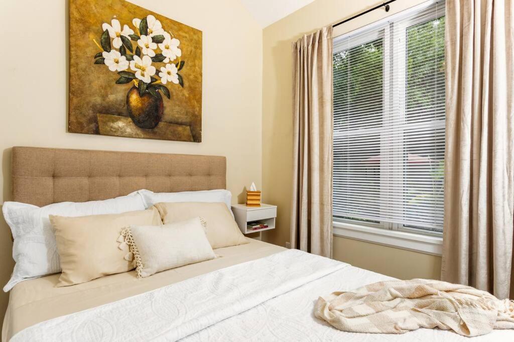 a bedroom with a bed with a painting and a window at Downtown Tiny Life - Experience Tiny Living! in Orlando