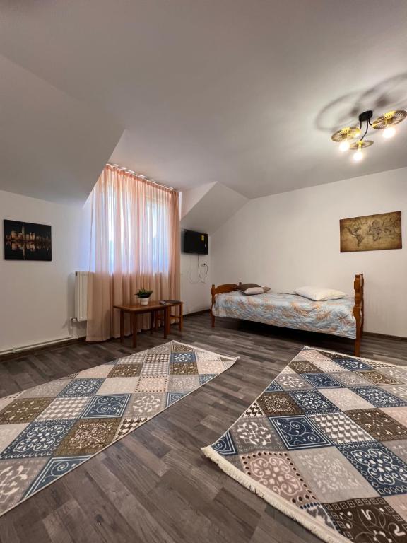 una camera con un letto e due tappeti sul pavimento di Casa Maria Sarata Monteoru a Sărata-Monteoru