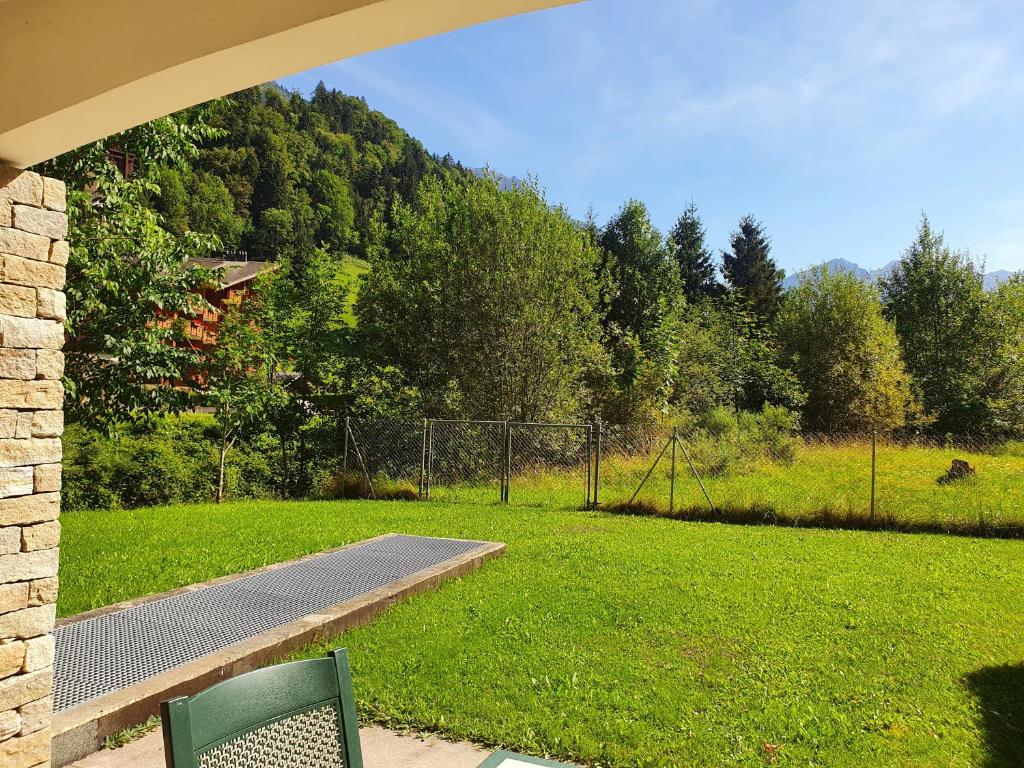 einem grünen Stuhl auf einem Feld mit einem Zaun in der Unterkunft Alpine Retreat Val D'Illiez in Val dʼIlliez
