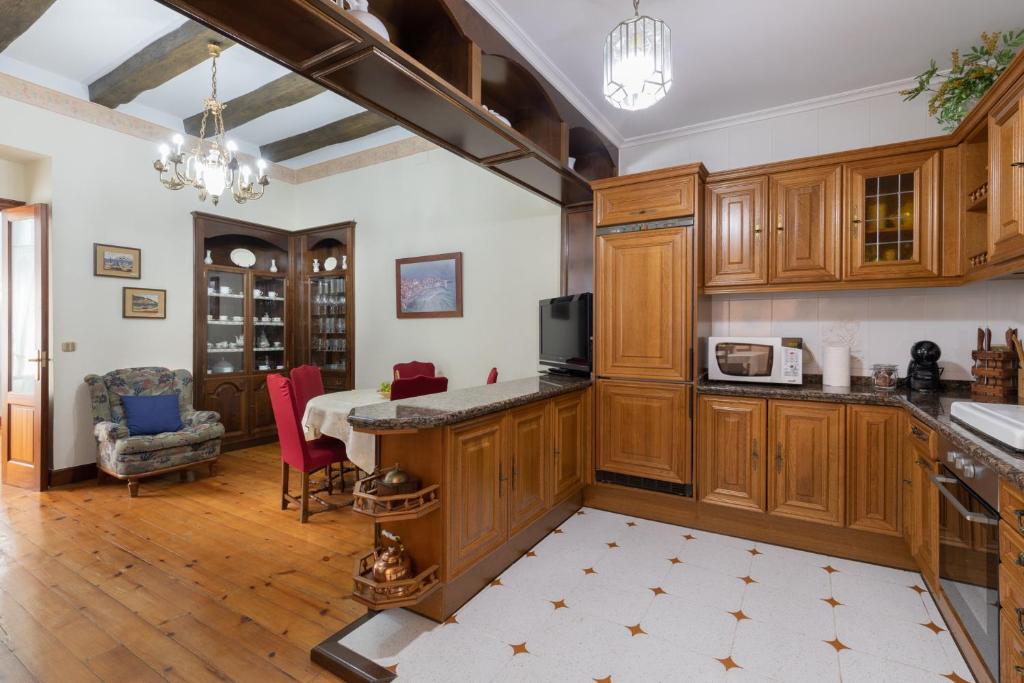 a kitchen with wooden cabinets and a dining room at Jauregi - baskeyrentals in Lekeitio