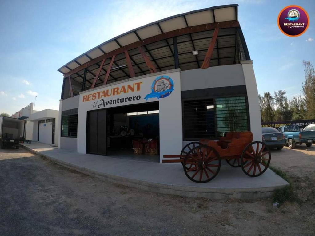 un bâtiment devant lequel se trouve une calèche tirée par des chevaux dans l'établissement Restaurant El Aventurero, à San Cristóbal