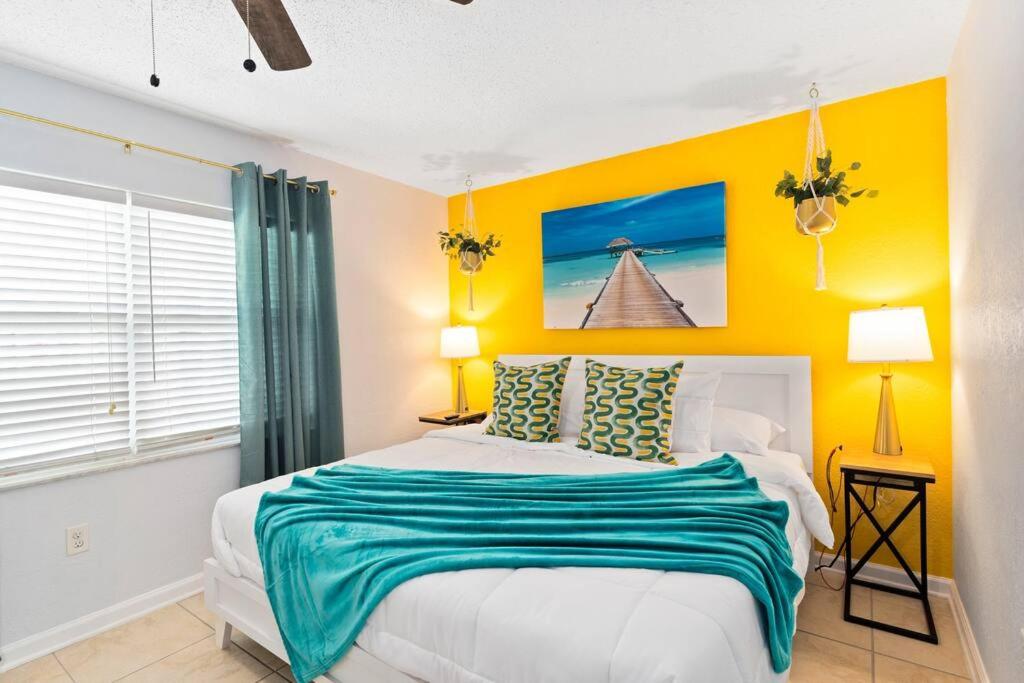 1 dormitorio con cama y pared amarilla en Beachside 4, en Indian Harbour Beach