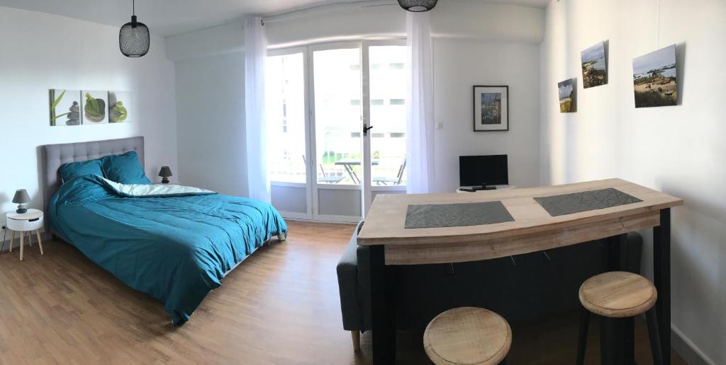 une chambre avec un lit et un bureau dans l'établissement Studio Le Saint Paul, Granville, à Granville