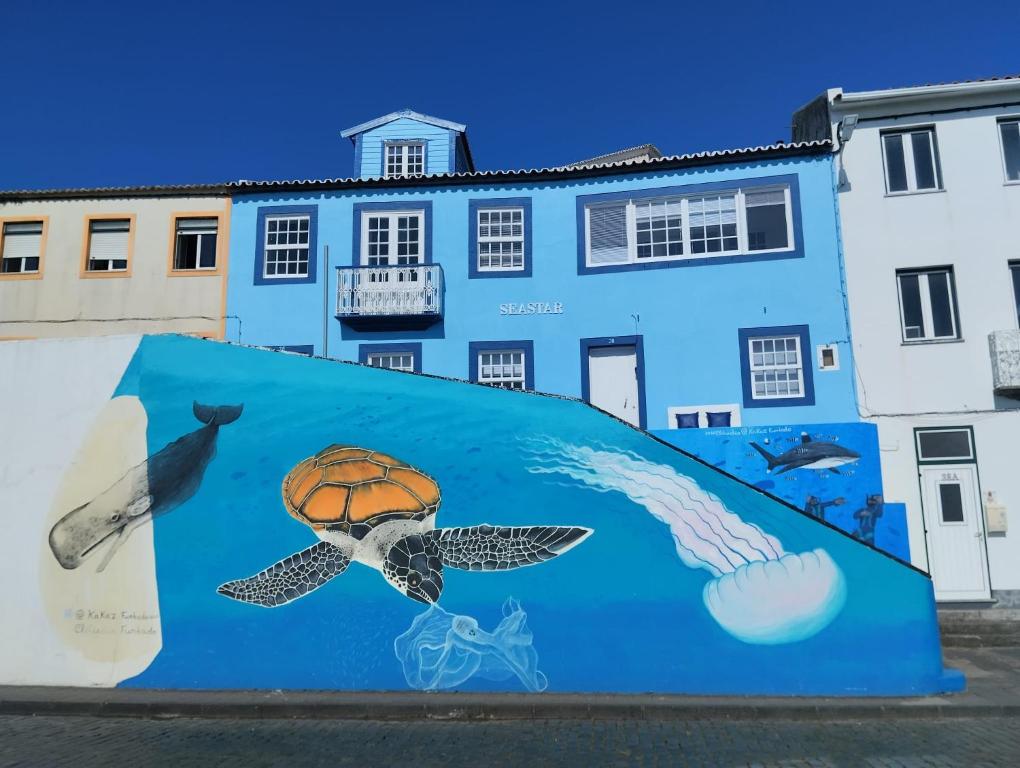 a mural on a wall in front of a building at SEASTAR nº38 in Horta