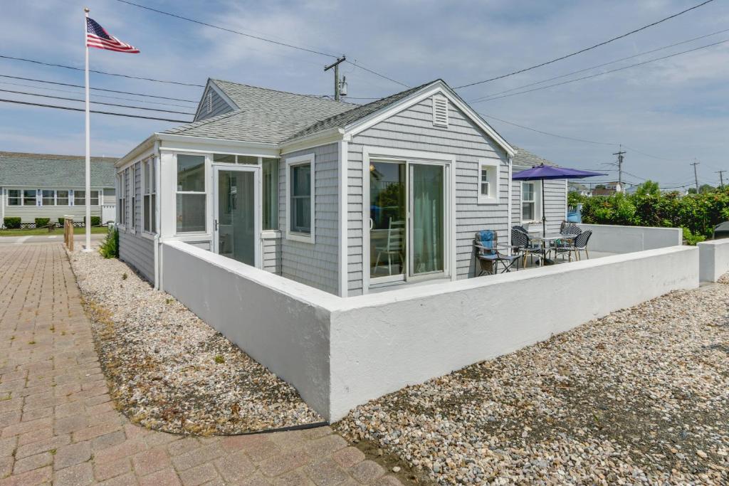 a small white house with a porch at Cozy Westbrook Vacation Rental - Walk to Beach! in Westbrook