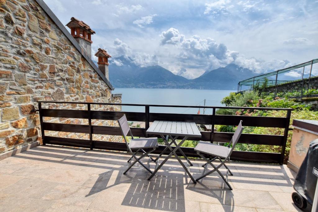 a table and chairs on a balcony with a view of a lake at Villa Betty in San Siro