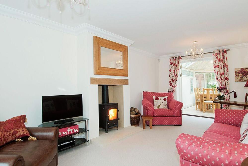 a living room with a couch and a fire place at Kissing Gate Cottage in Ebrington