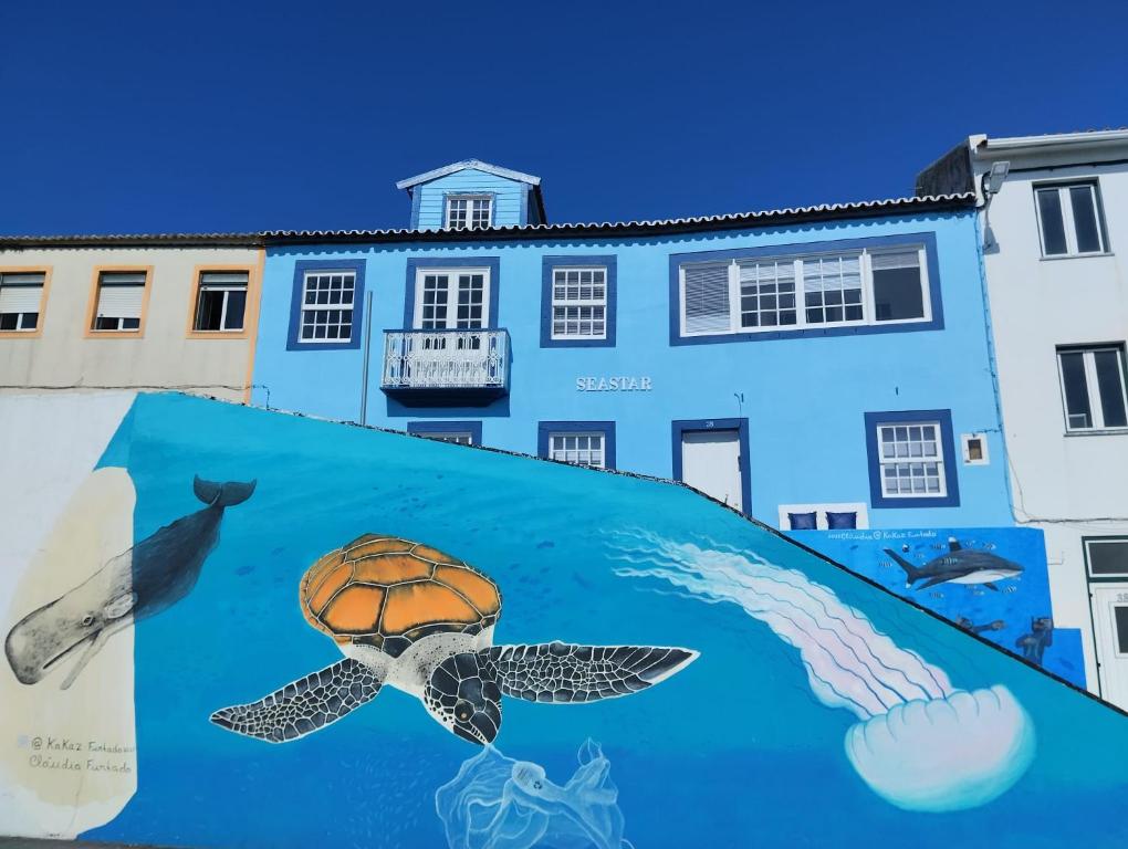 um mural em frente a um edifício azul em SEASTAR nº36 em Horta