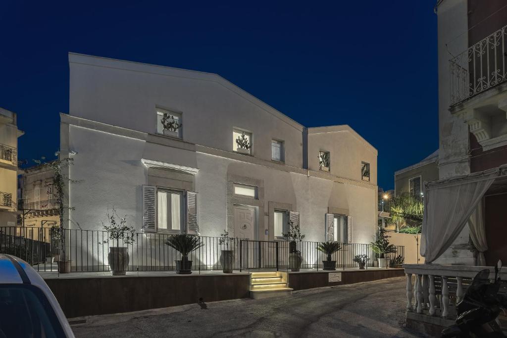 un bâtiment blanc avec des plantes sur son côté dans l'établissement Casa Vacanze "Oceano mare", à Pozzallo