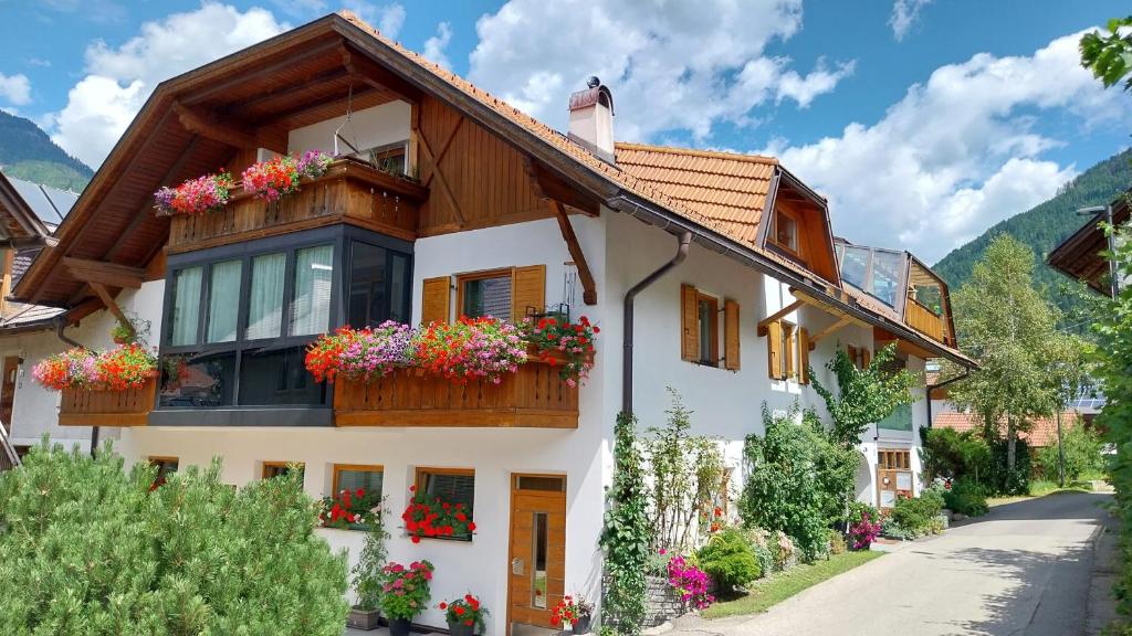 una casa con flores en sus ventanas en Bio.top.Appartement, en Rasun di Sopra