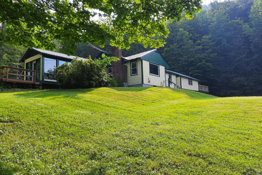 une maison au sommet d'une colline herbeuse avec une maison dans l'établissement Valkyrie Run, à Bridgewater