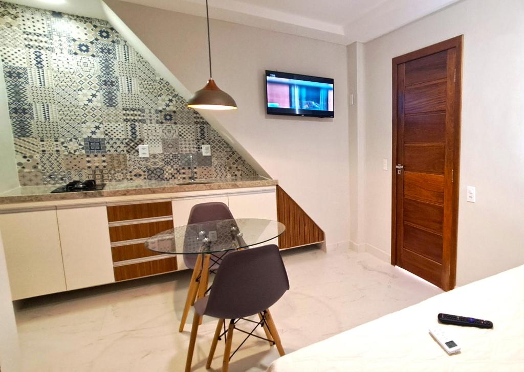 a kitchen with a glass table and two chairs at Flat da Eliete e Admilson 2 in Porto Seguro