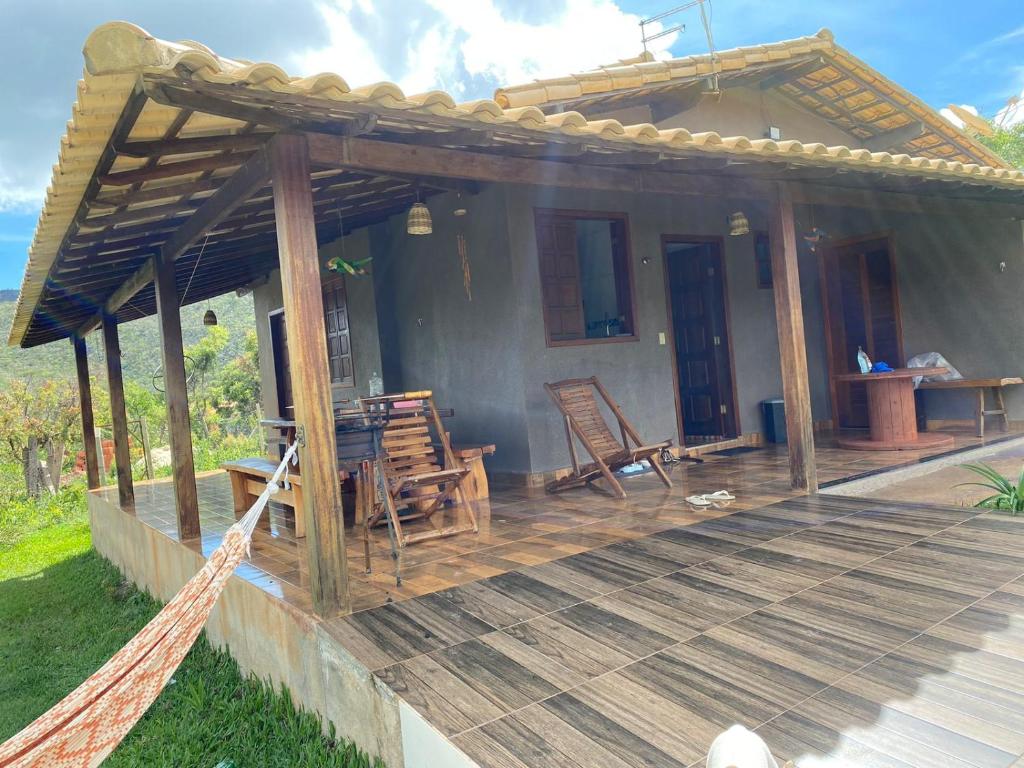 eine Veranda eines Hauses mit einer Holzterrasse in der Unterkunft Casa da Seriema em Lapinha da Serra in Santana do Riacho