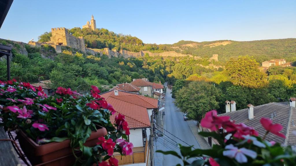 a view of a town with pink flowers on a balcony at Къща за гости Великите in Veliko Tŭrnovo