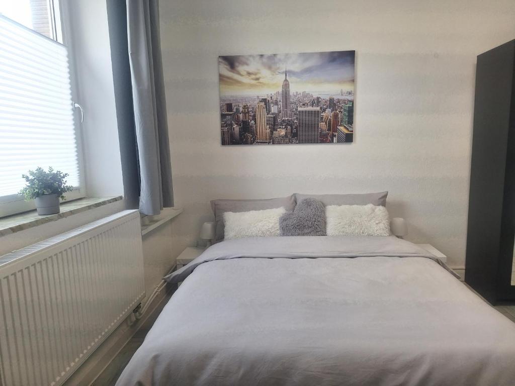 a bedroom with a bed with a picture on the wall at Studio Apartment 14 - 2L2 in Essen