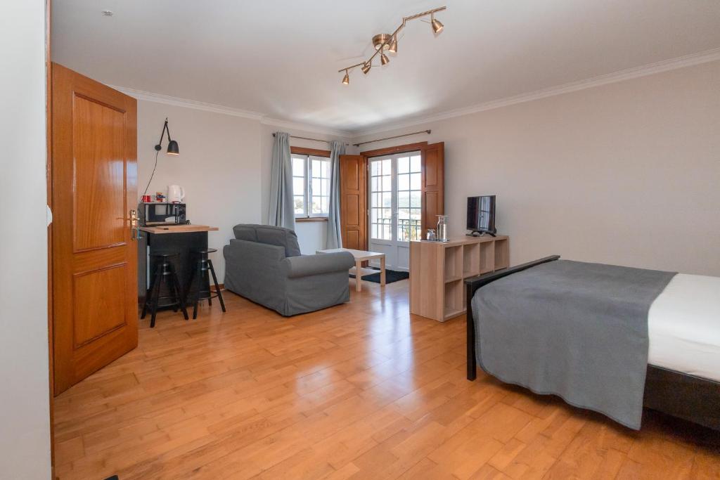 a bedroom with a bed and a chair and a desk at Galo Preto - Sintra Guesthouse in Sintra
