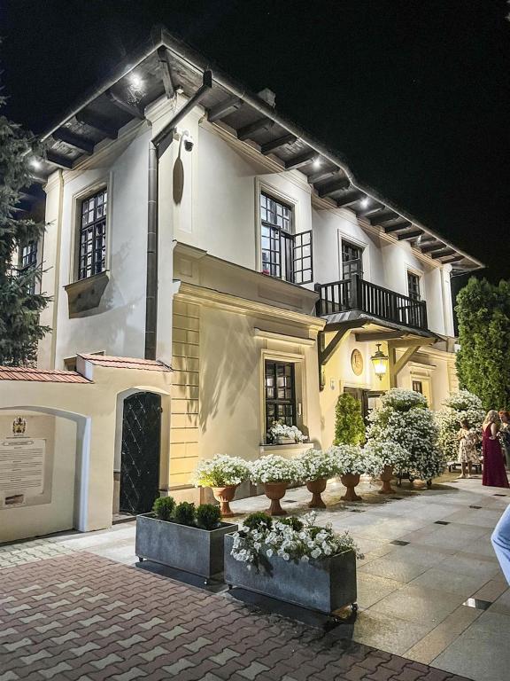 CiecierzynDwór Anna的前面有盆栽植物的大白色建筑