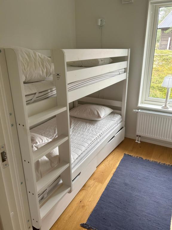 ein weißes Etagenbett in einem Zimmer mit Fenster in der Unterkunft Joängets Fjällgård 18a in Sälen