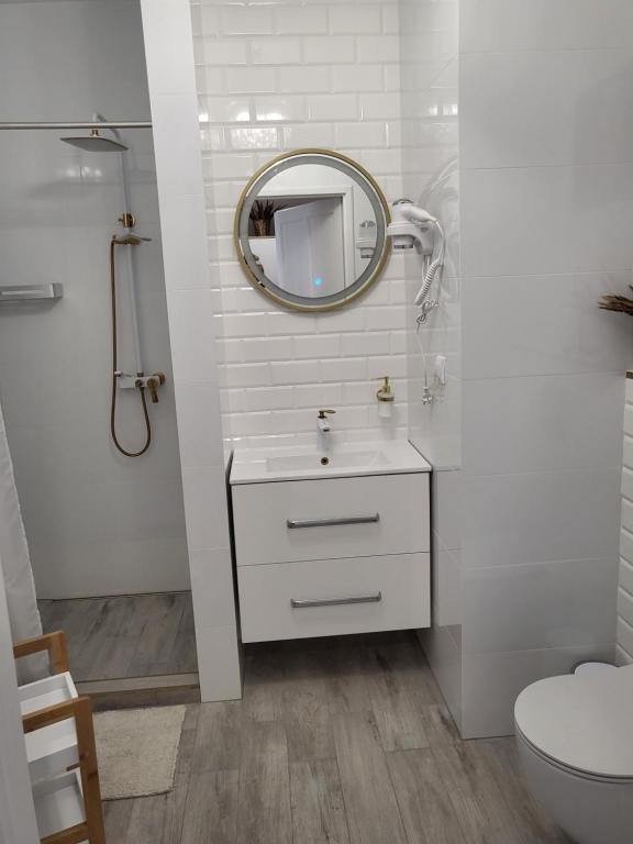 a white bathroom with a sink and a mirror at Pokój z własną kuchnią i łazienką Żyrardów SUNTAGO in Żyrardów