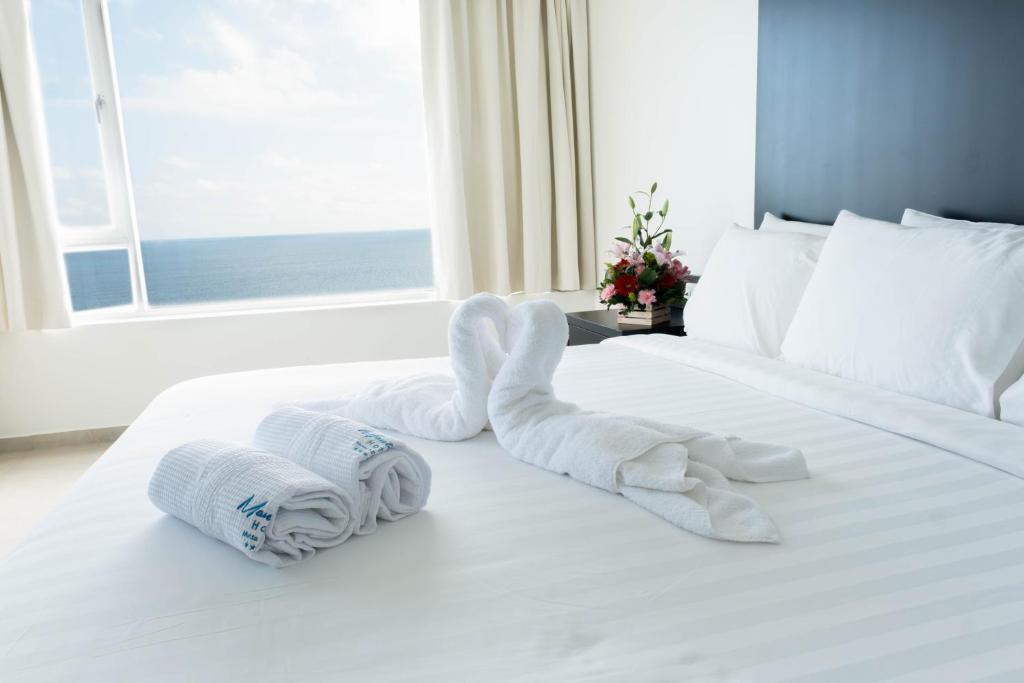 una pila de toallas sentadas encima de una cama en MantaHost Hotel en Manta