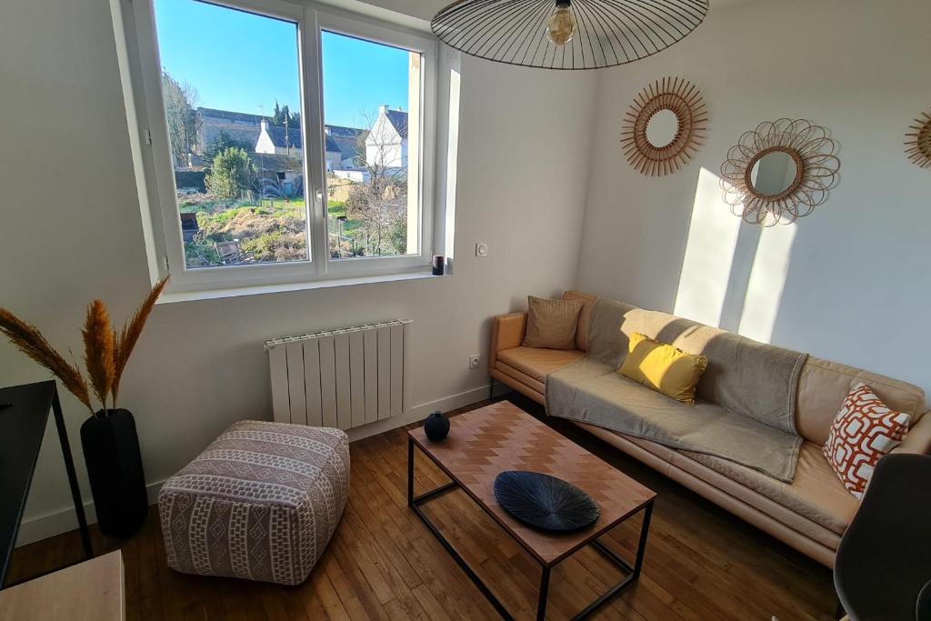 ein Wohnzimmer mit einer Couch und einem Couchtisch in der Unterkunft Le Jaures 4 - T2 - 1er Etage in Hennebont