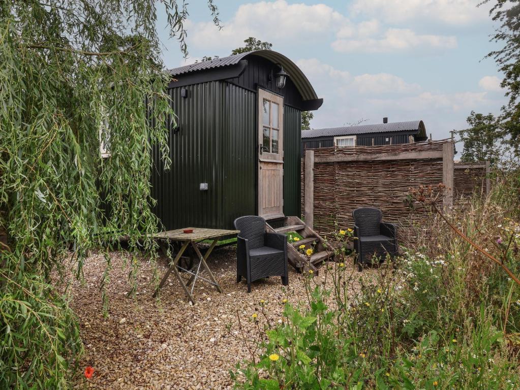 a black shed with chairs and a table in a yard at Whitehedge in York