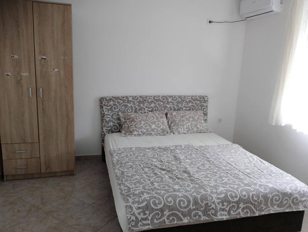 a bedroom with a bed and a wooden cabinet at Mica apartmani in Sutomore