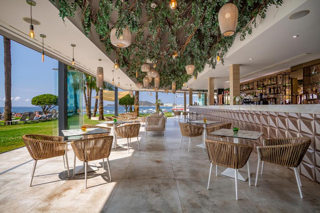 a restaurant with tables and chairs and a bar at Hotel Torre del Mar - Ibiza in Playa d'en Bossa